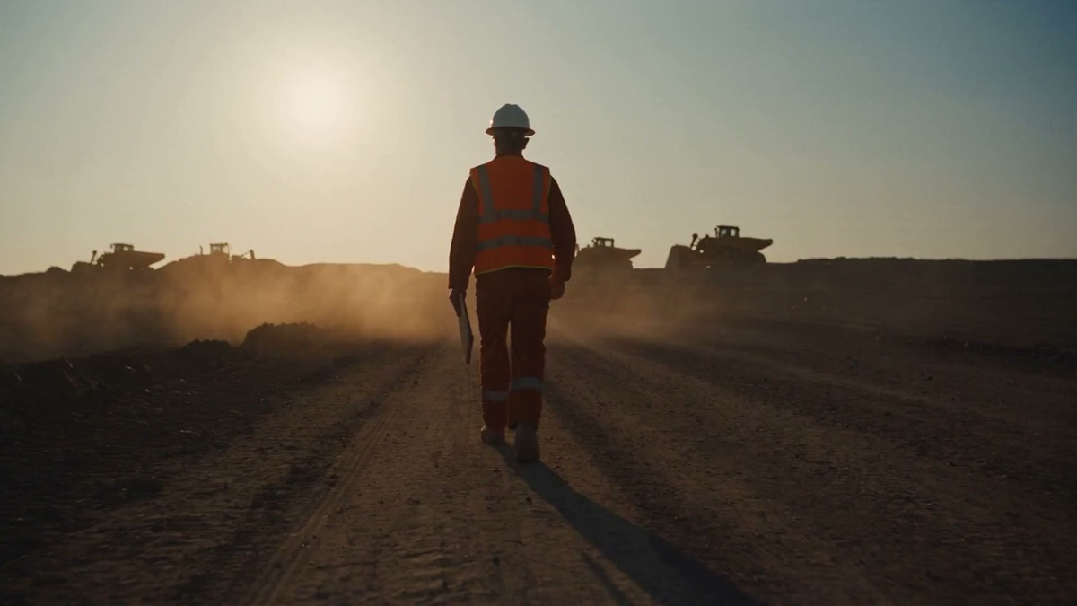 A safety professional walking a jobsite at sunrise
